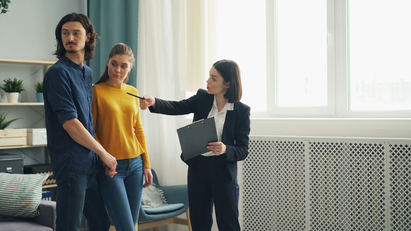 An agent with buyers in a bright living room